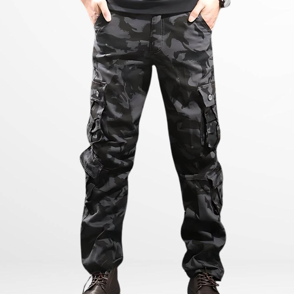 Man wearing sleek black camo cargo pants paired with brown leather boots, featuring a modern military-inspired design with practical pockets for utility.