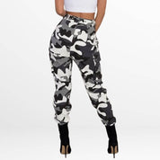 Back perspective showcasing the Camo Cargo Pants High-Waisted in a striking black and white camo, outlining the high-rise fit and back pockets, paired with high-heeled boots.