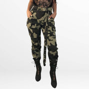 Camo Cargo Pants High-Waisted in a green camouflage pattern, shown from the front, accentuating the fitted waist and utility pocket design, matched with a black fitted top and boots.