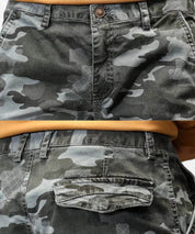 Close-up of men's grey camo cargo pants detailing with button and pattern texture.