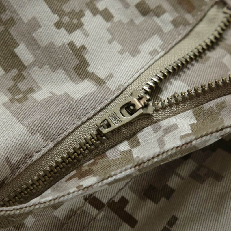 Detailed view of the zipper and button closure on military desert camo pants, highlighting the sturdy construction.