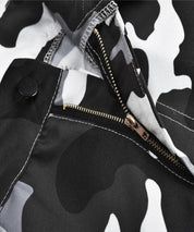 Detailed view of the zipper and button on the pocket of women's black and white camo cargo pants.