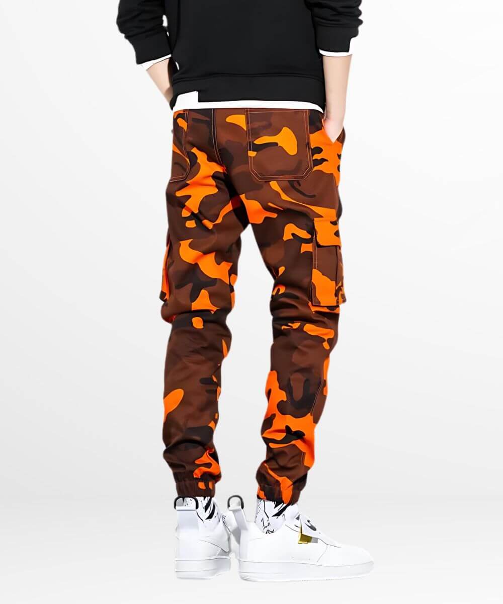 Back view of camo and orange cargo pants showing pocket details, styled with white high-top sneakers for urban streetwear flair.