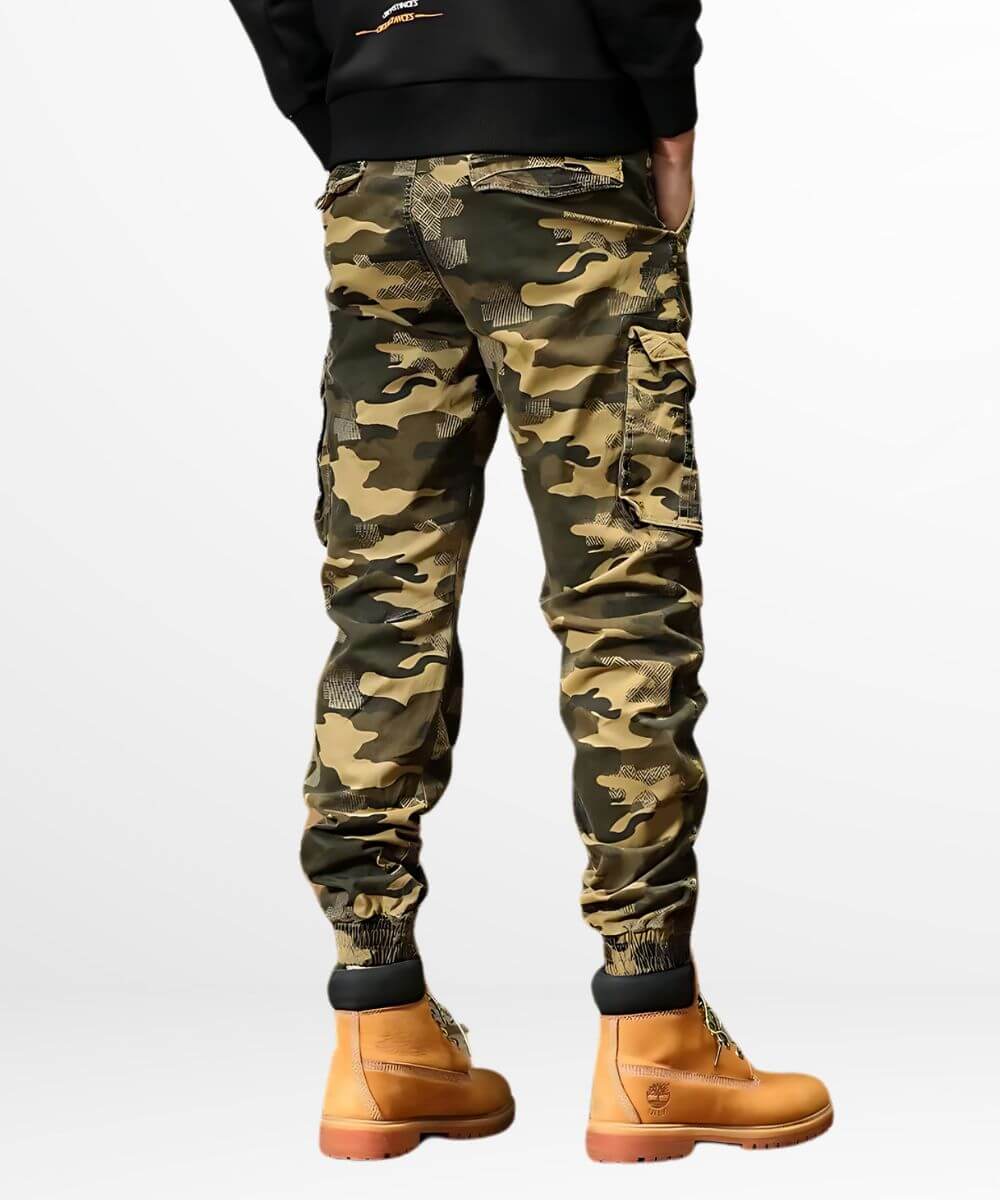 Rear view of khaki camo cargo jogger pants featuring spacious pockets and cuffed ankles, paired with tan lace-up boots for rugged style.