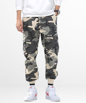 Front view of a man wearing baggy camo pants for a casual, relaxed fit, with hands in pockets and paired with white sneakers.