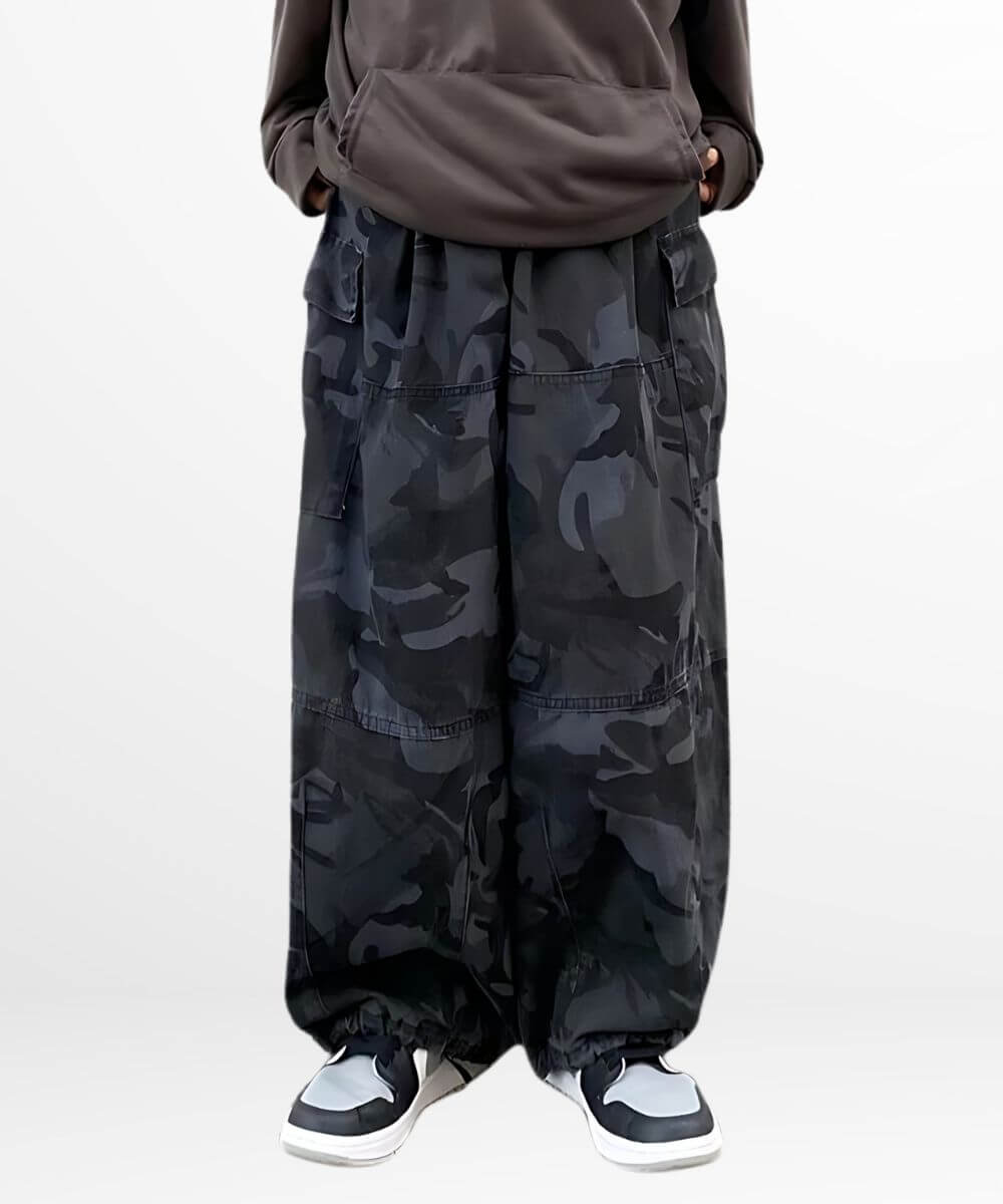 Front view of a woman wearing baggy camouflage pants with a comfortable, oversized fit and detailed pocket design.