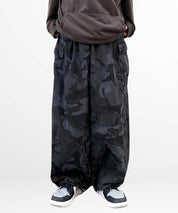 Front view of a woman wearing baggy camouflage pants with a comfortable, oversized fit and detailed pocket design.