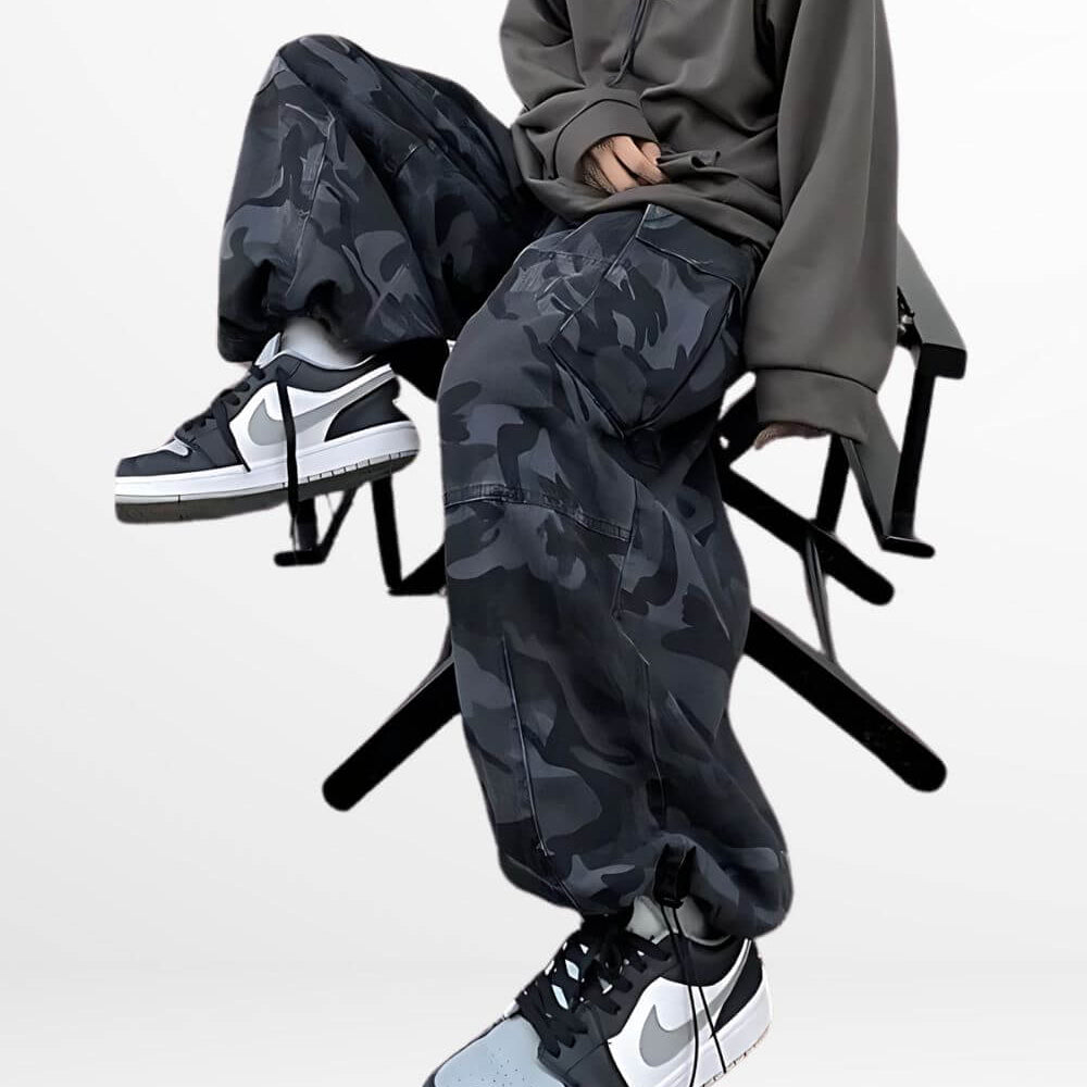 A seated woman showcasing the relaxed fit of baggy camouflage pants, complete with stylish high-top sneakers.
