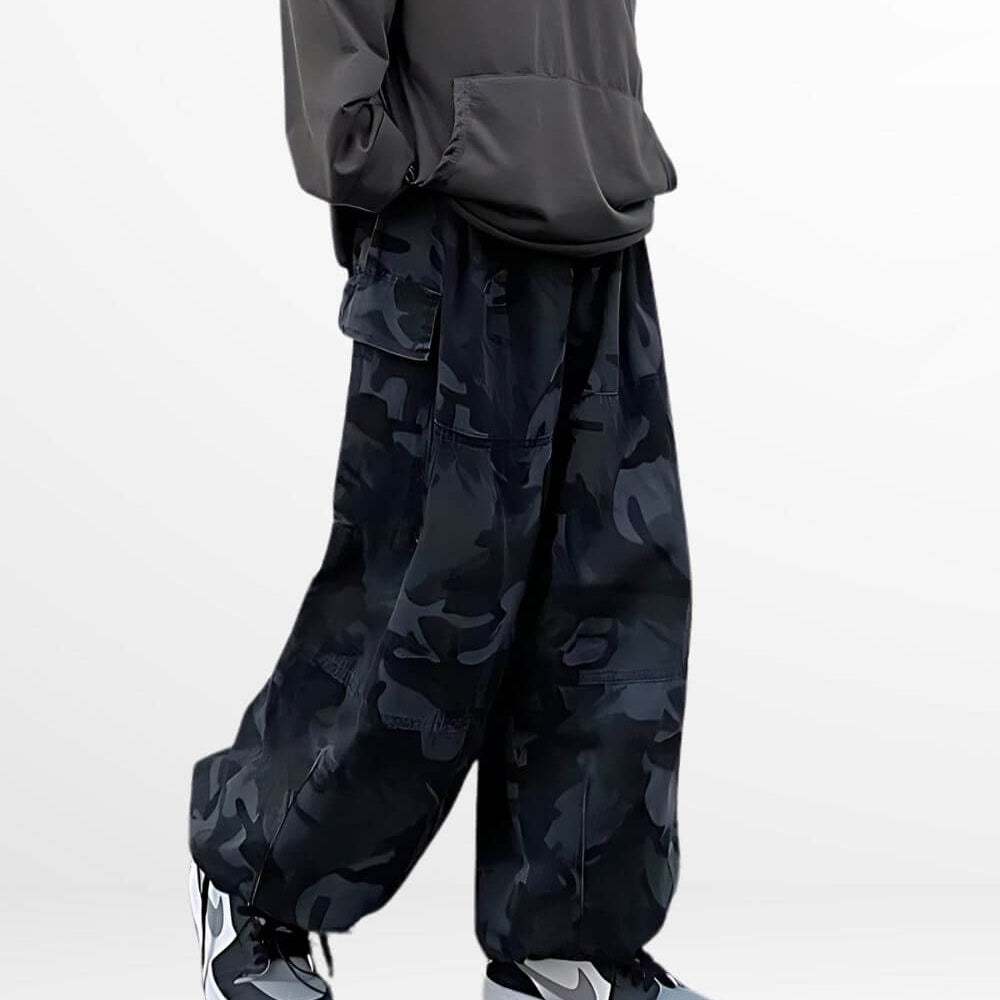 Side view of a woman standing in baggy camouflage pants paired with trendy black and white sneakers.