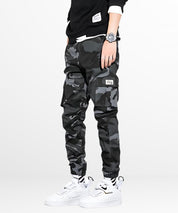 Side view of black and gray camo cargo pants mens with a focus on the cargo pocket detail and relaxed fit.
