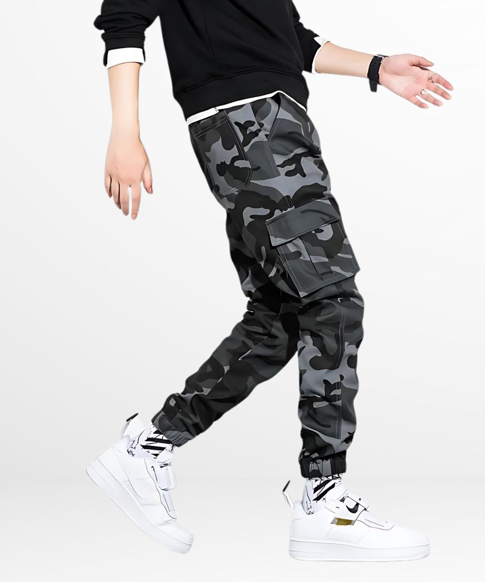 Man walking in black and gray camo cargo pants, showcasing the active wearability and street style.