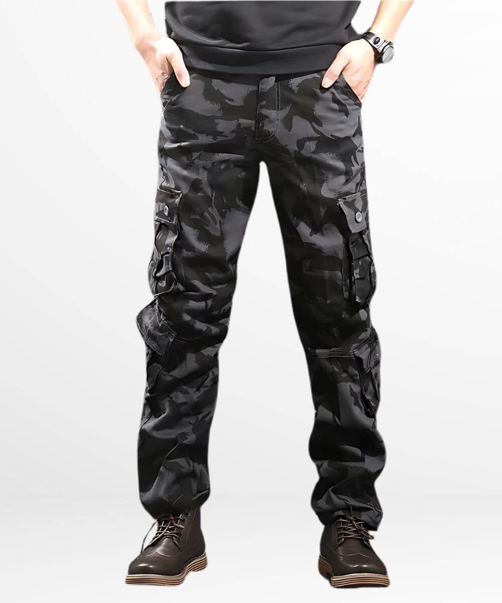 Man wearing black camo cargo pants with a tactical bag, ideal for outdoor activities, featured in a dark camouflage pattern with durable boots for rugged terrain.