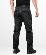 Back view of a man wearing black camo combat pants, highlighting the utility pockets and rugged design for outdoor activities.