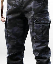 Side view of men's relaxed fit blue camouflage pants with cuffed ankles and tan boots.