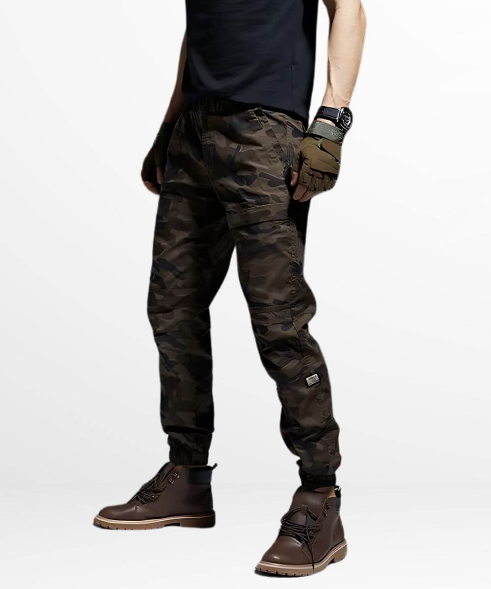 Side view of a man in brown camouflage pants with hands on hips, casual pose.