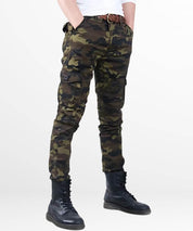 Angled view of a man wearing camo cargo pants in a slim fit cut, showcasing the side pockets and black boots.
