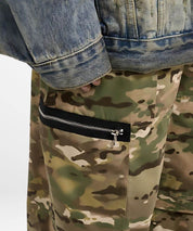 Close-up of a zipper pocket on baggy camouflage pants paired with a denim jacket.