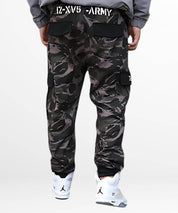Back view of a man in casual dark camo cargo pants with pocket details, emphasizing the streetwear vibe.