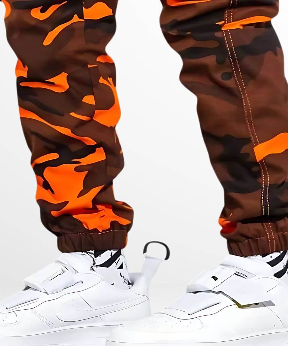 Close-up on the ankle cuff of camo and orange cargo pants, focusing on the elastic detail and fabric texture.