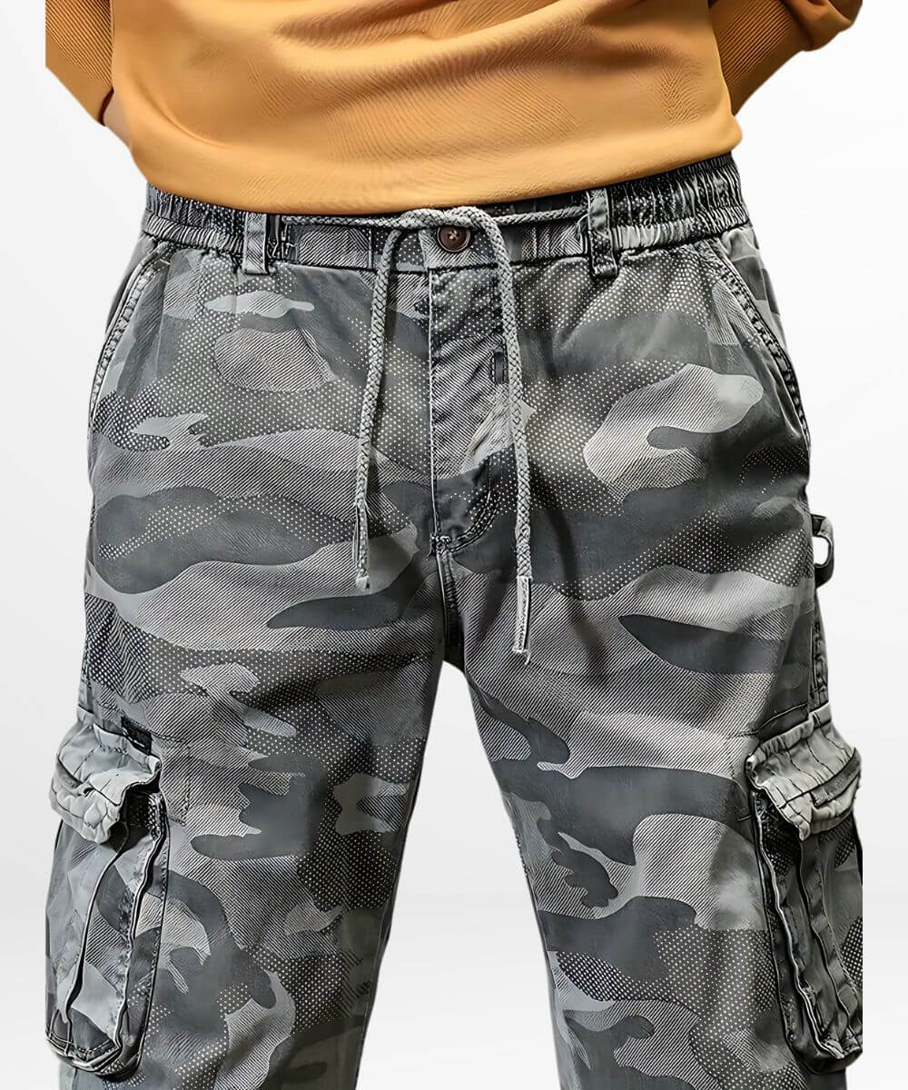 Contemporary streetwear men's cargo pants with blue camouflage design and ankle cuffs.