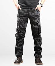 Front view of dark camo cargo pants with a focus on the detailed camouflage pattern and pocket design, matched with brown lace-up boots.