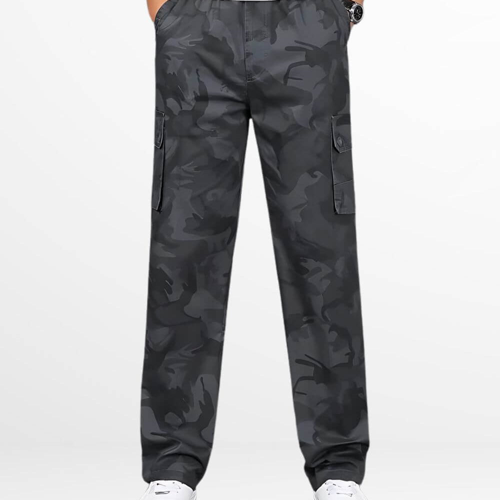 Front view of dark grey camouflage pants showcasing detailed pockets and a relaxed fit, paired with white sneakers.