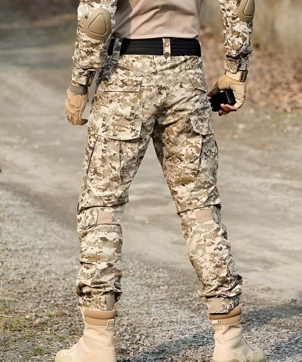Back view of desert camo pants for men in an outdoor setting, showcasing the adaptive camouflage and tactical pockets for utility.