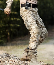 Side view of a man in action pose wearing desert camo pants for men, featuring reinforced knee pads and rugged outdoor design.
