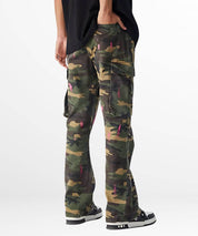Back view of green and pink camouflage pants highlighting rear pockets and black sneakers.