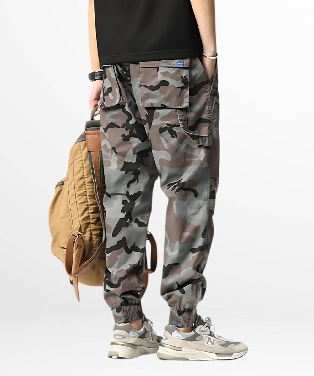 Side view of a person carrying a brown backpack, wearing grey camo cargo sweatpants that offer a blend of functionality and street fashion.