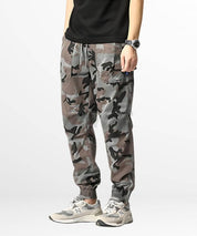 Closeup of grey camo cargo sweatpants focusing on the pocket detail and drawstring closure, highlighting the fusion of comfort and urban style.