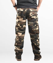 Back view of a man wearing khaki cargo and camo pants for men, focusing on the detailed pocket design.