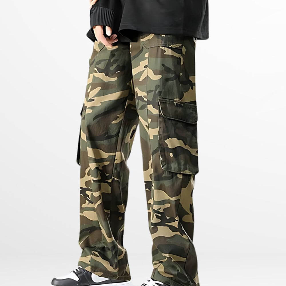 Men's baggy camo cargo pants styled with classic black and white sneakers, paired with a black sweater for a relaxed urban look.
