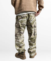 Back view of men's baggy camo pants showing the loose fit and cargo pockets, teamed with durable work boots for a functional outfit.