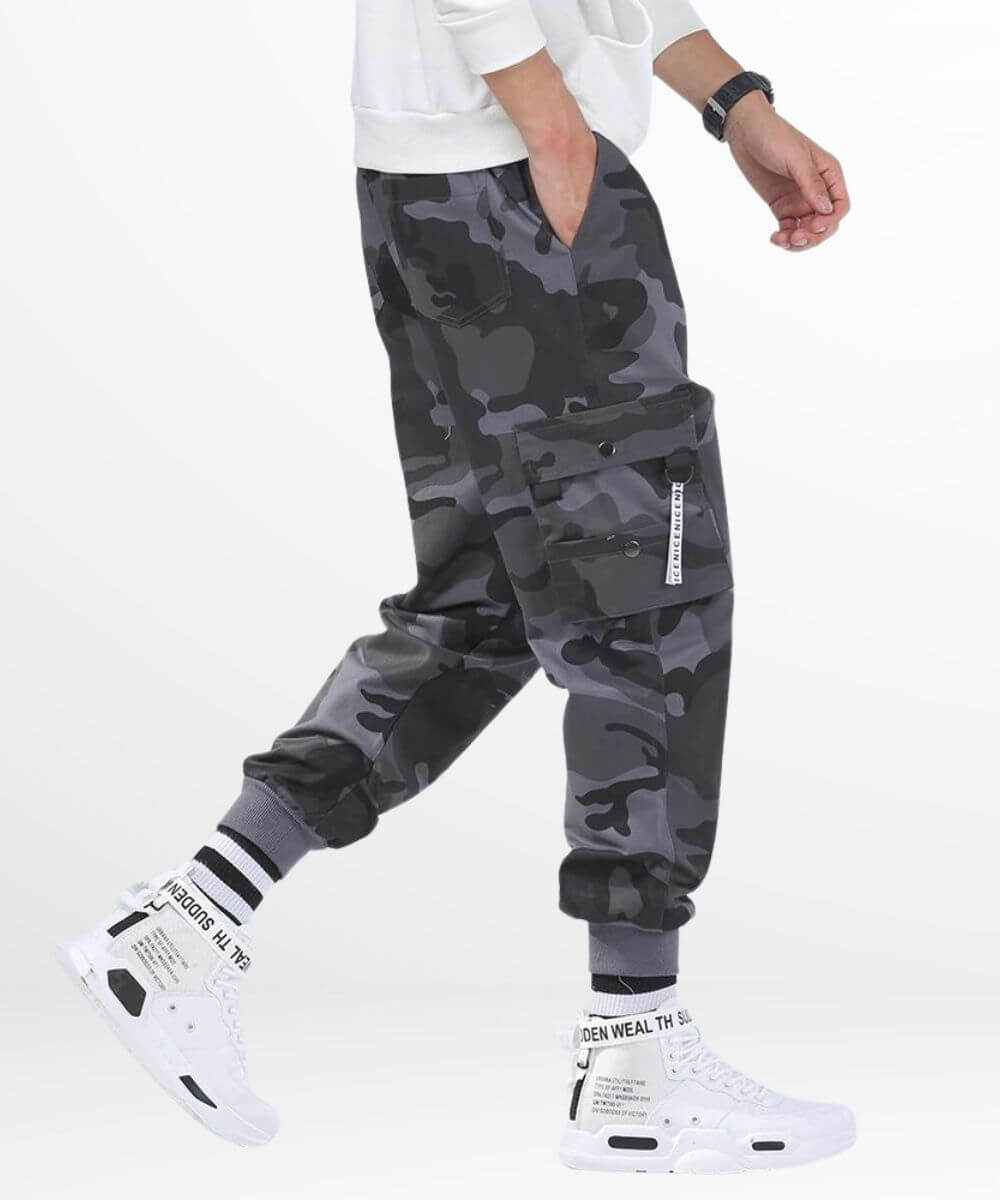 Side view of a man in motion wearing men's baggy grey camo cargo pants, highlighting the dynamic fit and functional design.