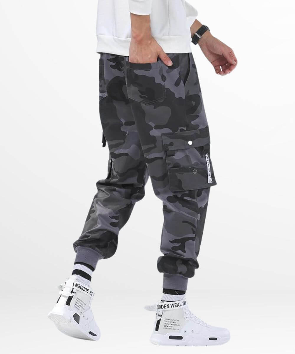 Detailed side view of men's baggy grey camo cargo pants showing off the utility pocket design and comfortable streetwear style.