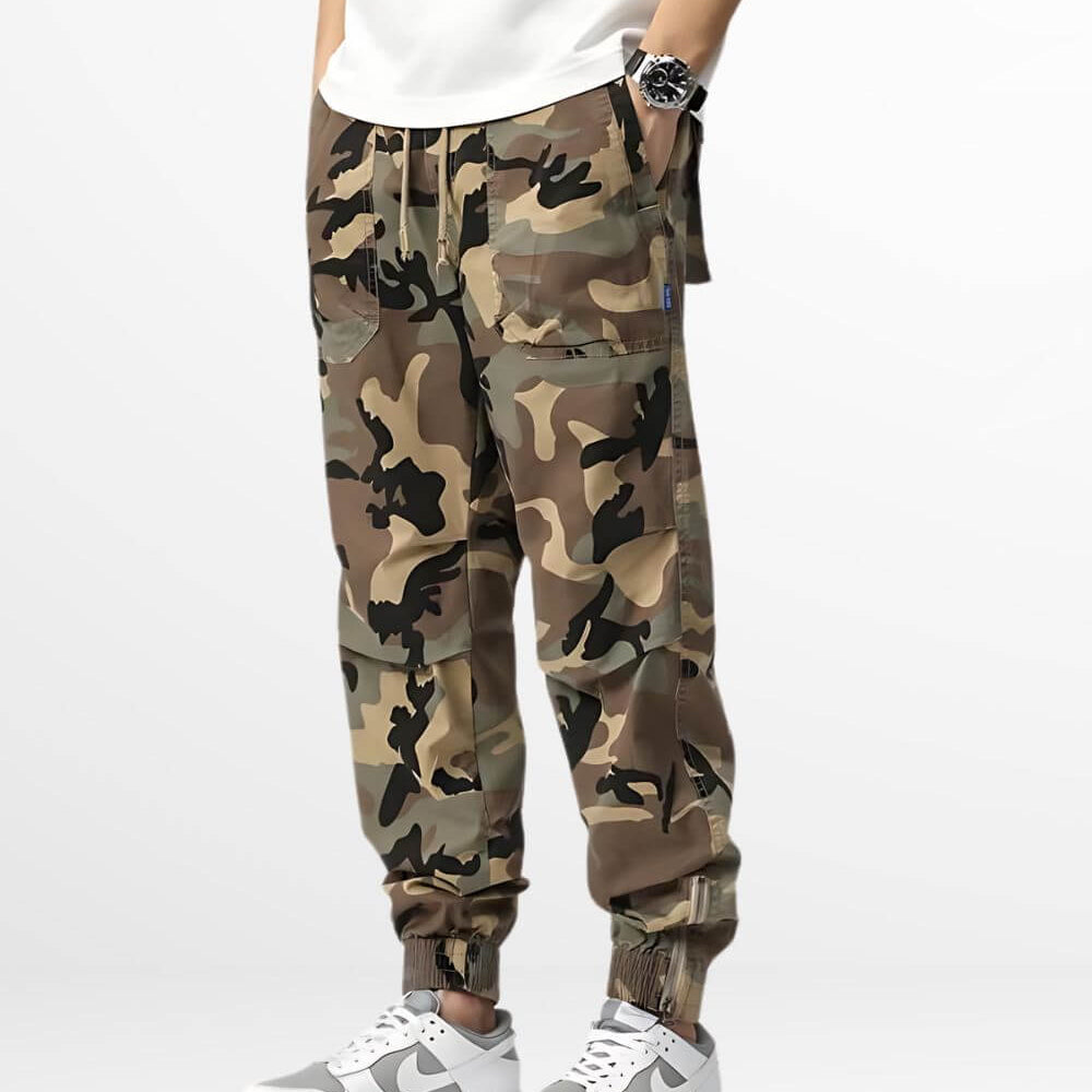 Man wearing camouflage cargo sweatpants paired with white sneakers and a simple white t-shirt, showcasing a casual and trendy streetwear look.