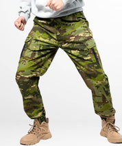 Action pose showing the flexibility of men's camouflage hunting pants with tactical boots.