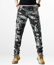 Front view of men's grey and black skinny camo cargo pants paired with tan boots.