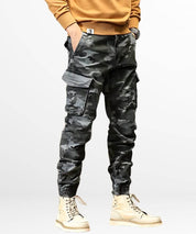 Stylish full-body view of mens grey camo cargo jogger pants paired with trendy beige boots, perfect for urban streetwear fashion.