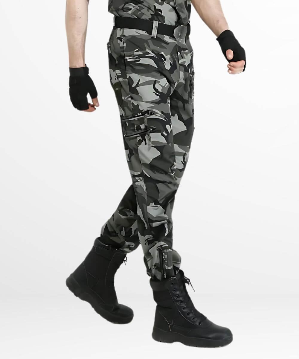 Side view of a man wearing grey camo cargo pants, showcasing the side pockets and fit along with black tactical gloves and boots.