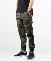 Side angle of men's trendy cargo camo pants, focusing on the utility side pocket and snug ankle fit.