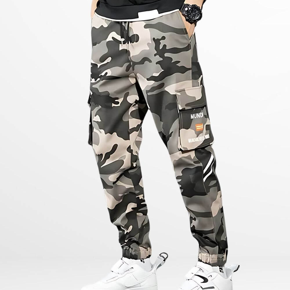 Man in urban camouflage cargo pants paired with white sneakers and a casual black tee.