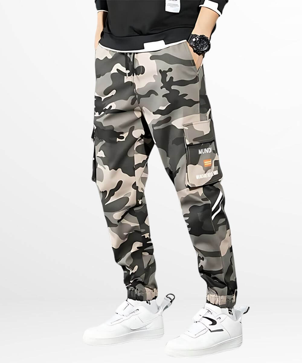 Man in urban camouflage cargo pants paired with white sneakers and a casual black tee.