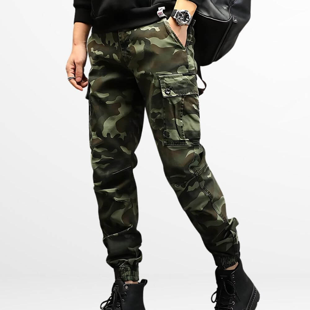 Man standing in military-style camo cargo pants featuring reinforced knee patches and black combat boots.