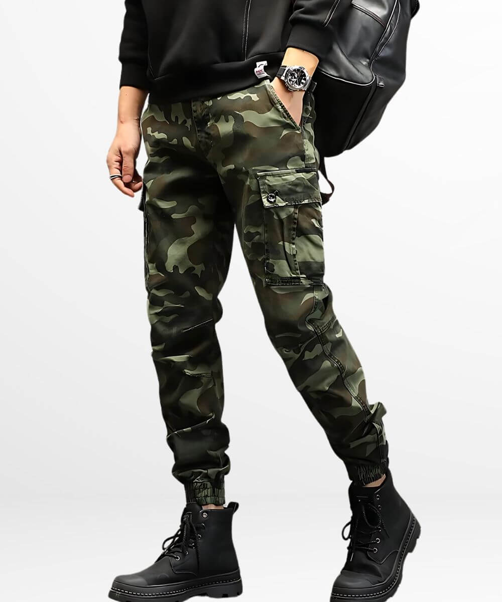 Man standing in military-style camo cargo pants featuring reinforced knee patches and black combat boots.