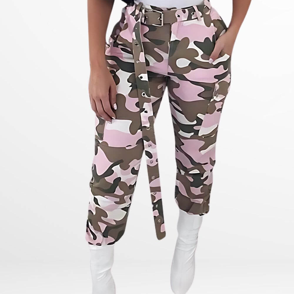 Woman showcasing pink camouflage pants paired with white boots, front view, modern urban style.