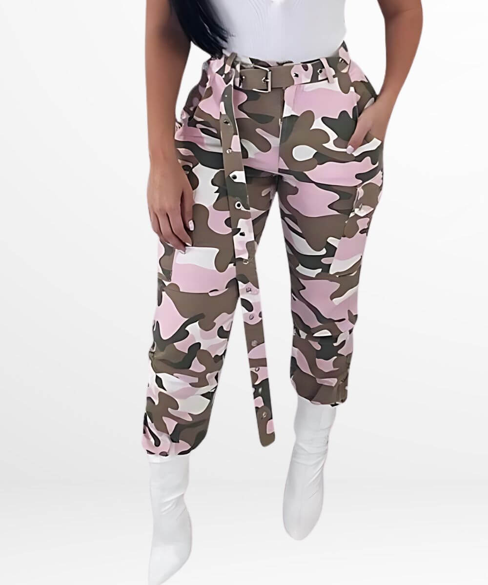 Woman showcasing pink camouflage pants paired with white boots, front view, modern urban style.