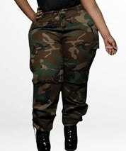 Plus-size women's camo pants in a stylish front view, paired with shiny black boots.