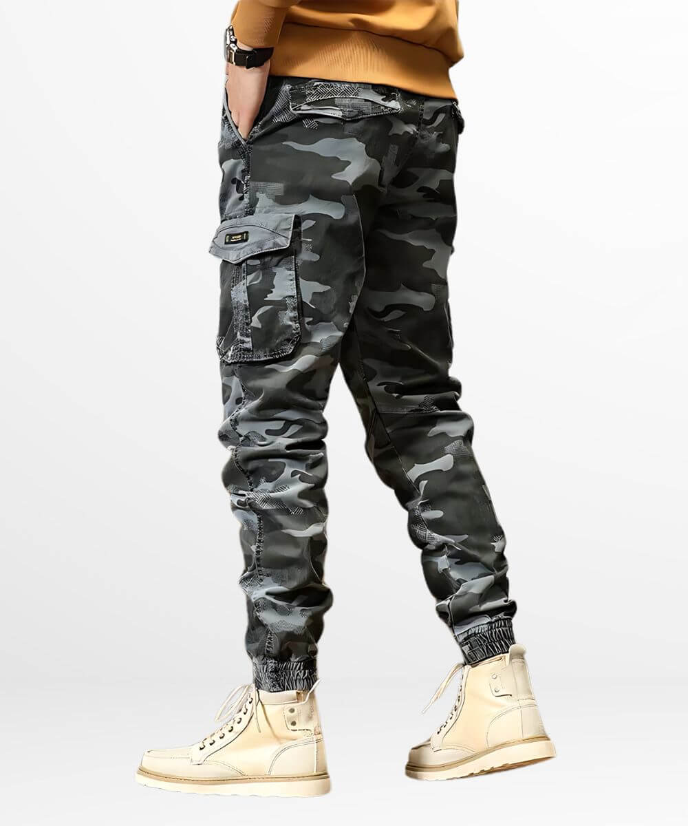Back view of mens grey camo cargo jogger pants showing the detailed cargo pocket, matched with high-top beige boots for a fashion-forward look.